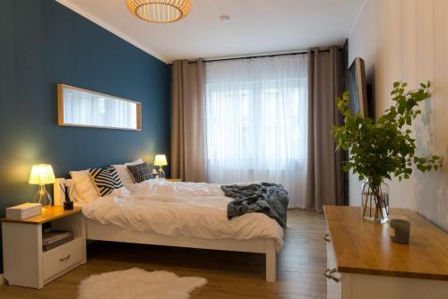 een slaapkamer met een bed en een blauwe muur bij VacationClub – Spokojna 24E Apartament C.1 in Wisła