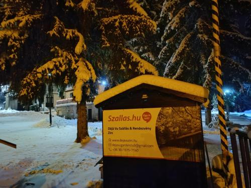 a snow covered donation box with a sign on it at Déjá Vu Szállás & Rendezvény Zirc in Zirc