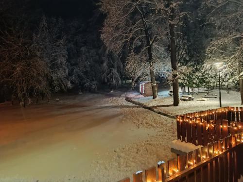 een met sneeuw bedekte straat met een hek en verlichting bij Déjá Vu Szállás & Rendezvény Zirc in Zirc