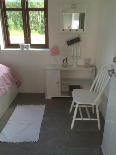 a bedroom with a chair and a desk and a window at Sellebjerg Apartment in Bindslev