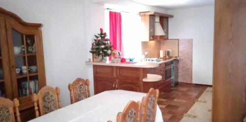 a kitchen with a table and chairs and a christmas tree at Domek w górach in Kluszkowce