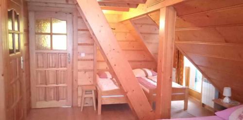 a bedroom with two beds in a wooden house at Domek w górach in Kluszkowce