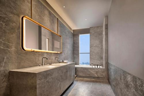 a bathroom with a large sink and a mirror at Artyzen NEW BUND 31 Shanghai Qiantan in Shanghai