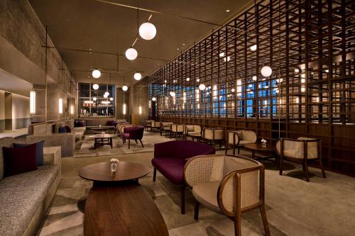 a restaurant with couches tables and chairs and windows at Artyzen NEW BUND 31 Shanghai Qiantan in Shanghai