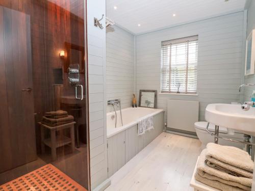 a bathroom with a tub and a toilet and a sink at Lampland House in Southwold