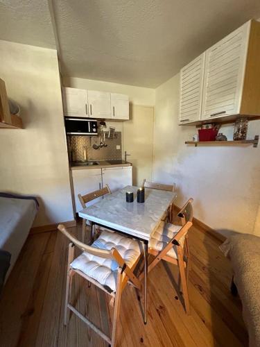 una cucina con tavolo e sedie in una stanza di appartement à la Foux d'Allos a La Foux