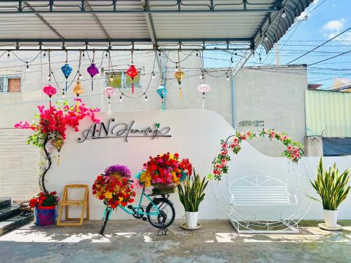 un vélo garé dans un garage fleuri dans l'établissement A.N Homestay, à Phan Thiết