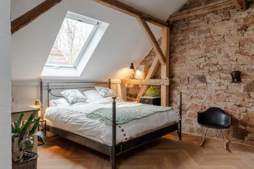 a bedroom with a bed and a brick wall at Boutique Ferienwohnung Schwalbenstall Uissigheim in Uissigheim