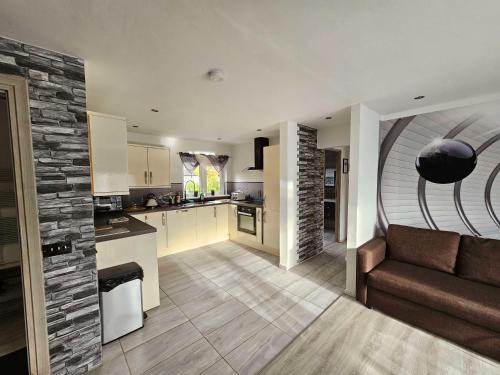 cocina y sala de estar con sofá y mesa en Modern Urban Haven: Stylish Getaway, en Knockmore