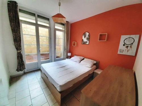 ein Schlafzimmer mit einem Bett und einem großen Fenster in der Unterkunft Appart chaleureux avec terrasse in Saumur