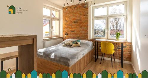 1 dormitorio con cama y pared de ladrillo en mN apartments home - Wieliczka Town, en Wieliczka