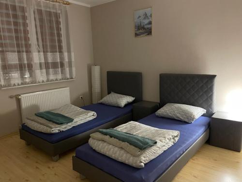 2 camas en una habitación con colchones azules en Apartament XXL, en Złotów