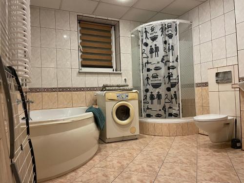 y baño con bañera, aseo y lavadora. en Apartament XXL, en Złotów