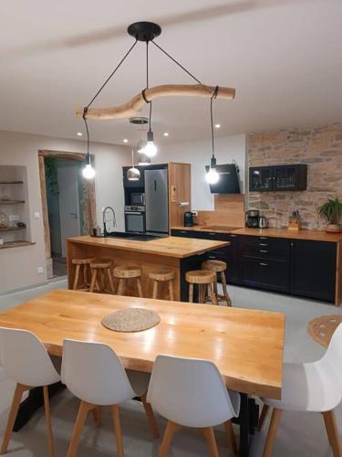 une cuisine avec une grande table et des chaises en bois dans l'établissement Maison authentique au pieds du vignoble de 135m2 6 personnes, à La Charme