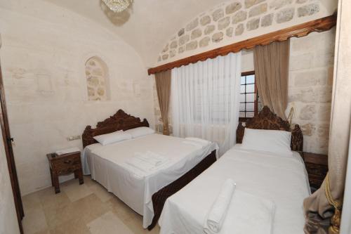 1 Schlafzimmer mit 2 Betten und einem Fenster in der Unterkunft ARTUKHAN BUTİK HOTEL in Mardin