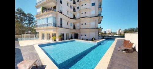 a building with a swimming pool in front of a building at 802 Maison Duplex para pessoas de bom gosto. in Joinville