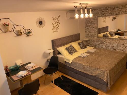 a bedroom with a bed and a table and a desk at Studio Apartment Lacus in Zagreb