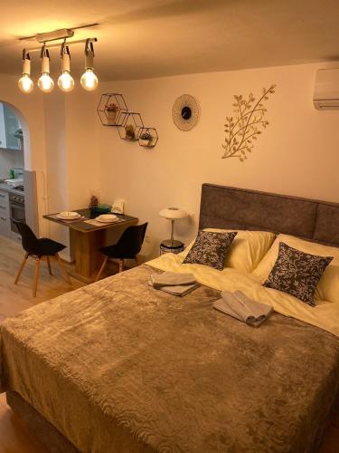 a bedroom with a large bed and a table with chairs at Studio Apartment Lacus in Zagreb