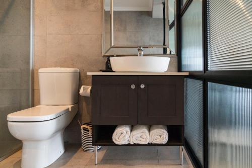 a bathroom with a sink and a toilet at Sunrise on Gazelle in Jeffreys Bay