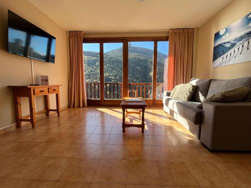 a living room with a couch and a large window at Wuau! Apartamentos Solana de Ransol in Ransol