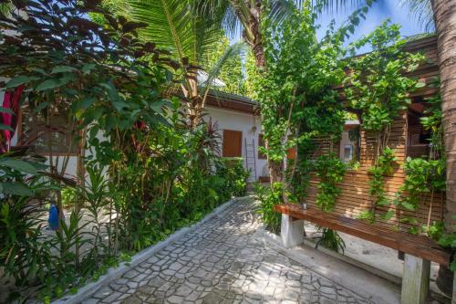 a bench in front of a building with trees at Dive Villa Thoddoo in Thoddoo
