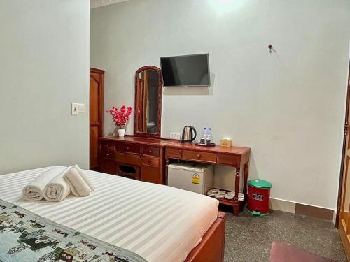 a bedroom with a bed and a dresser with a mirror at HONG PEP HOTEL in Battambang