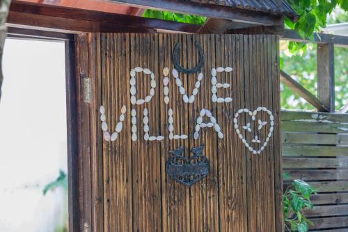 a wooden out house with a sign on it at Dive Villa Thoddoo in Thoddoo