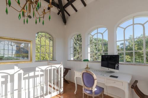 een kamer met een bureau, een computer en ramen bij VILLA TOJI luxury private - Adults only in Bracciano