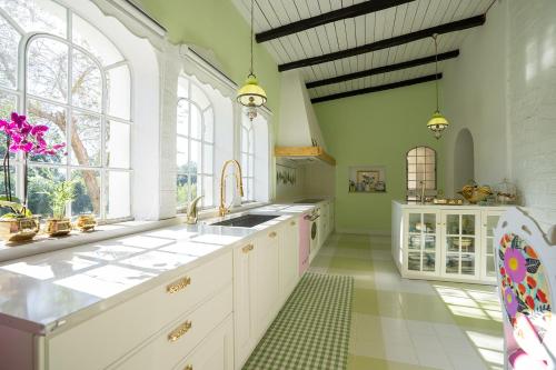 een keuken met witte kasten en een groot raam bij VILLA TOJI luxury private - Adults only in Bracciano