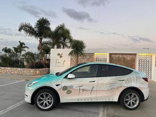 a small white car parked in a parking lot at TAF Beach Villas with Tesla in Tigaki