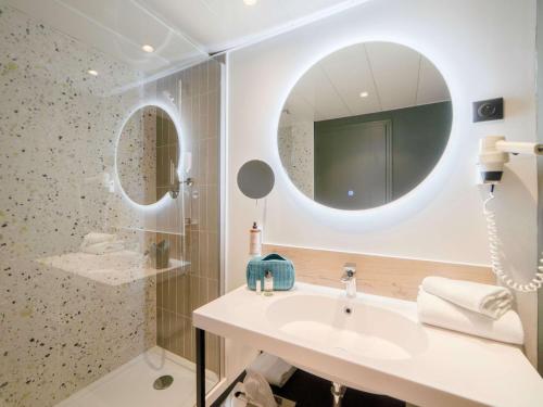 a bathroom with a sink and a mirror at Mercure Auxerre Autoroute du Soleil in Appoigny