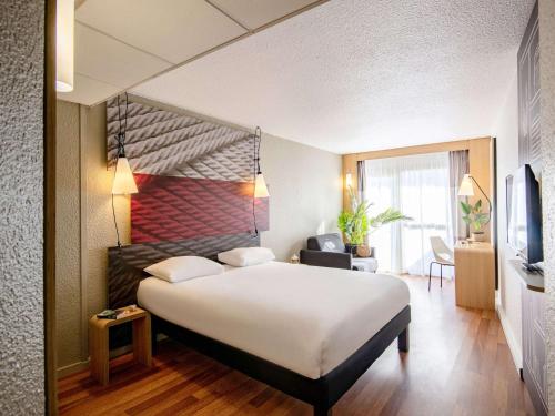 um quarto de hotel com uma cama grande num quarto em ibis Cannes Plage La Bocca em Cannes