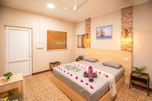 a bedroom with a bed with pink flowers on it at Dive Villa Thoddoo in Thoddoo