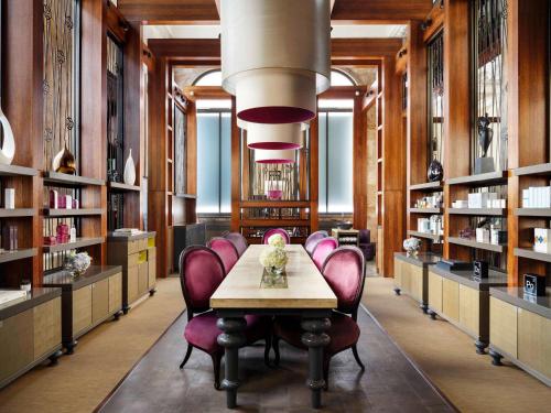 a library with a table and purple chairs at Sofitel London St James in London