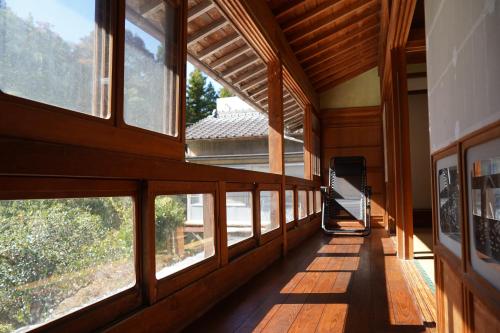 un corridoio di una casa con ampie finestre di TOSAYAMA BASE 清流沿いの里山　古民家貸切　高知市街地より車で約20分 a Kochi