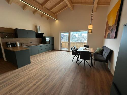 cocina y comedor con mesa y sillas en Appartement Kramerhaus, en Hollersbach im Pinzgau