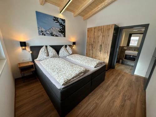 1 dormitorio con 1 cama con cabecero negro en Appartement Kramerhaus, en Hollersbach im Pinzgau