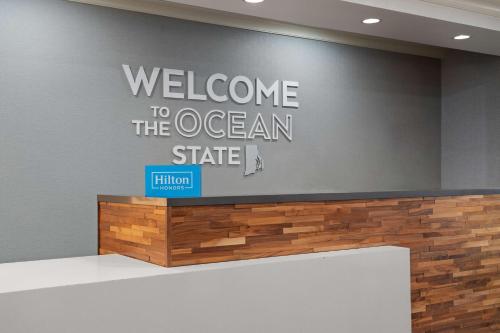 a welcome to the ocean state sign on a wall at Hampton Inn South Kingstown - Newport Area in South Kingstown