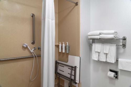 uma casa de banho com chuveiro e toalhas brancas em Hampton Inn South Kingstown - Newport Area em South Kingstown
