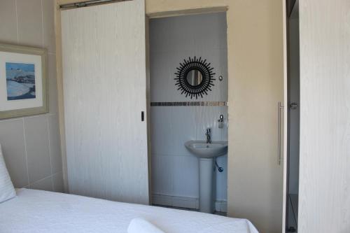 ein Bad mit einem Waschbecken und einem Spiegel in der Unterkunft Lapeng La Heso guest in Mogwase