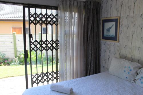 Schlafzimmer mit einem Bett und einer Glasschiebetür in der Unterkunft Lapeng La Heso guest in Mogwase
