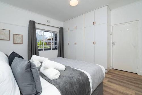 sypialnia z łóżkiem z poduszkami i oknem w obiekcie Two bedroom House in Claremont w Kapsztadzie