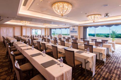 a conference room with tables and chairs and chandeliers at Hilton Tokyo Narita Airport in Narita
