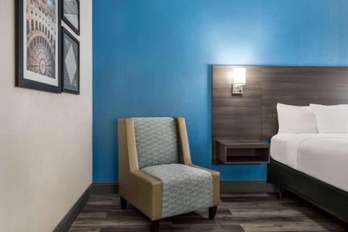 a bedroom with a bed and a chair in a room at La Quinta by Wyndham Round Rock North in Round Rock