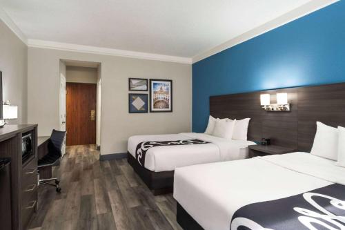 a hotel room with two beds and a desk at La Quinta by Wyndham Round Rock North in Round Rock