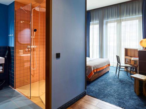 a hotel room with a shower and a bedroom at 25hours Hotel Hamburg HafenCity in Hamburg