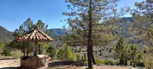 a tree and a tower with a view of a mountain at Hostal Almenara in Paterna del Madera