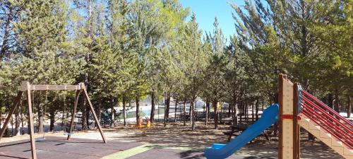 a playground with a slide and a swing at Hostal Almenara in Paterna del Madera