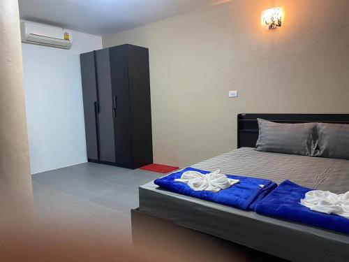 a bedroom with a bed with two towels on it at ทับศิลารีสอร์ท Tubsila Resort in Chongsadao
