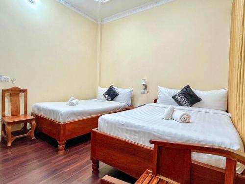 a bedroom with two beds and a table at HONG PEP HOTEL in Battambang